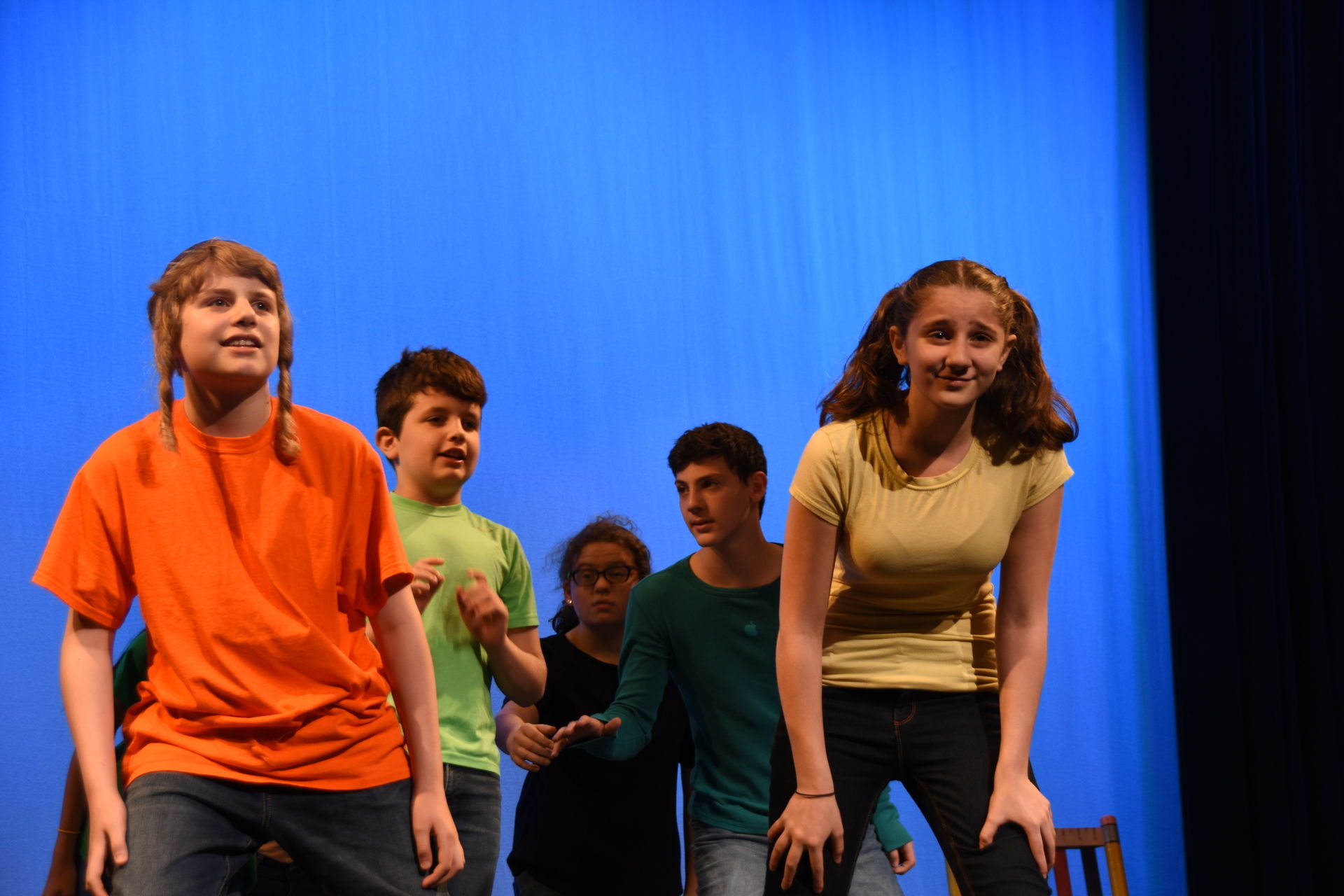 Children on stage with moody lighting.